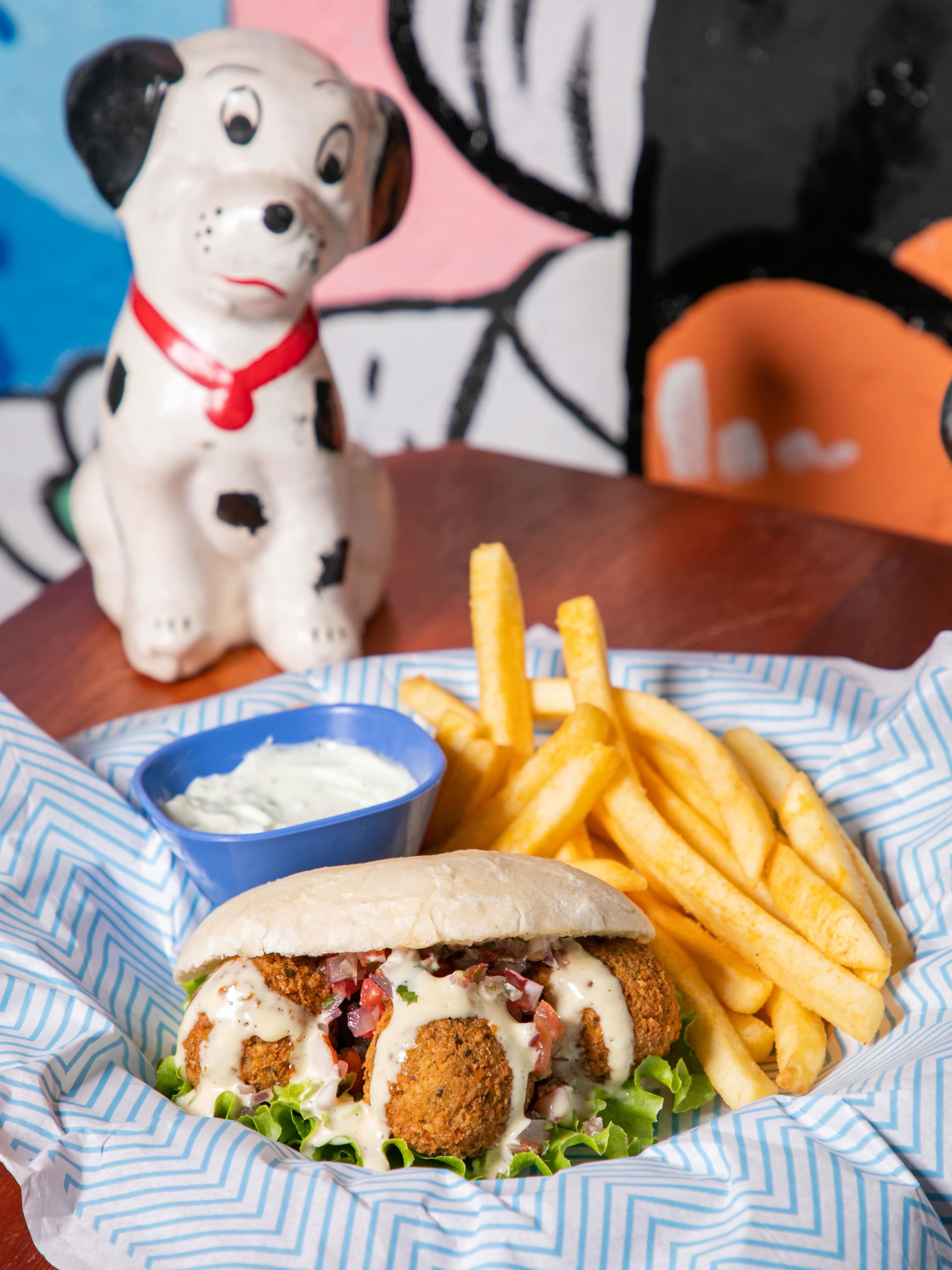 Falafel pita con papas fritas, con un dálmata de cerámica atrás